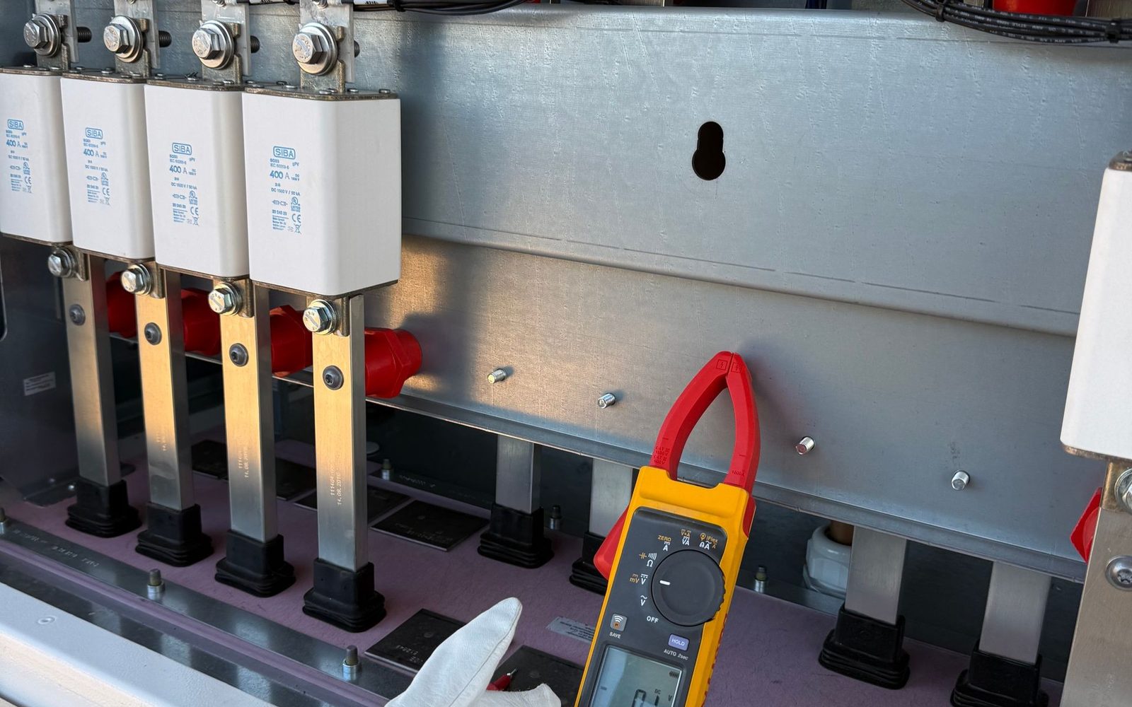 Electrician testing a modern electrical panel with a clamp meter